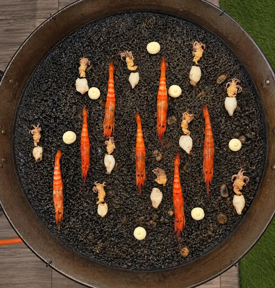 Arroz negro con gambas, chipirones y alioli